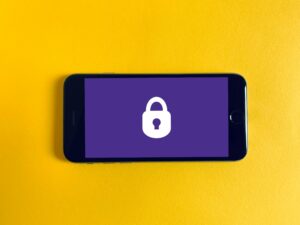 Governance and security - a phone laid on a yellow background, the phone screen is purple with a white padlock