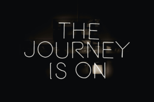 Implementing AI. A neon sign that reads, 'the journey is on'