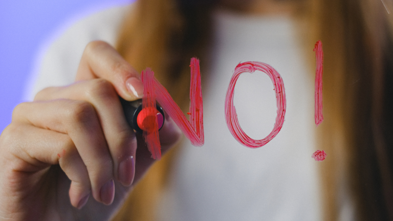 Not every problem needs AI - women writing 'no' on a clear board with lipstick